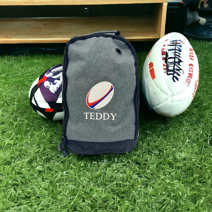 Personalised embroidered rugby boot bag in grey with the name Teddy in white  with rugby balls